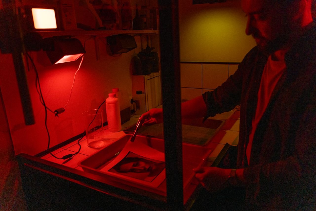 Mastering the First Impression: Your intriguing post title goes here A photographer develops film in a darkroom under red light, showcasing the classic processing method.