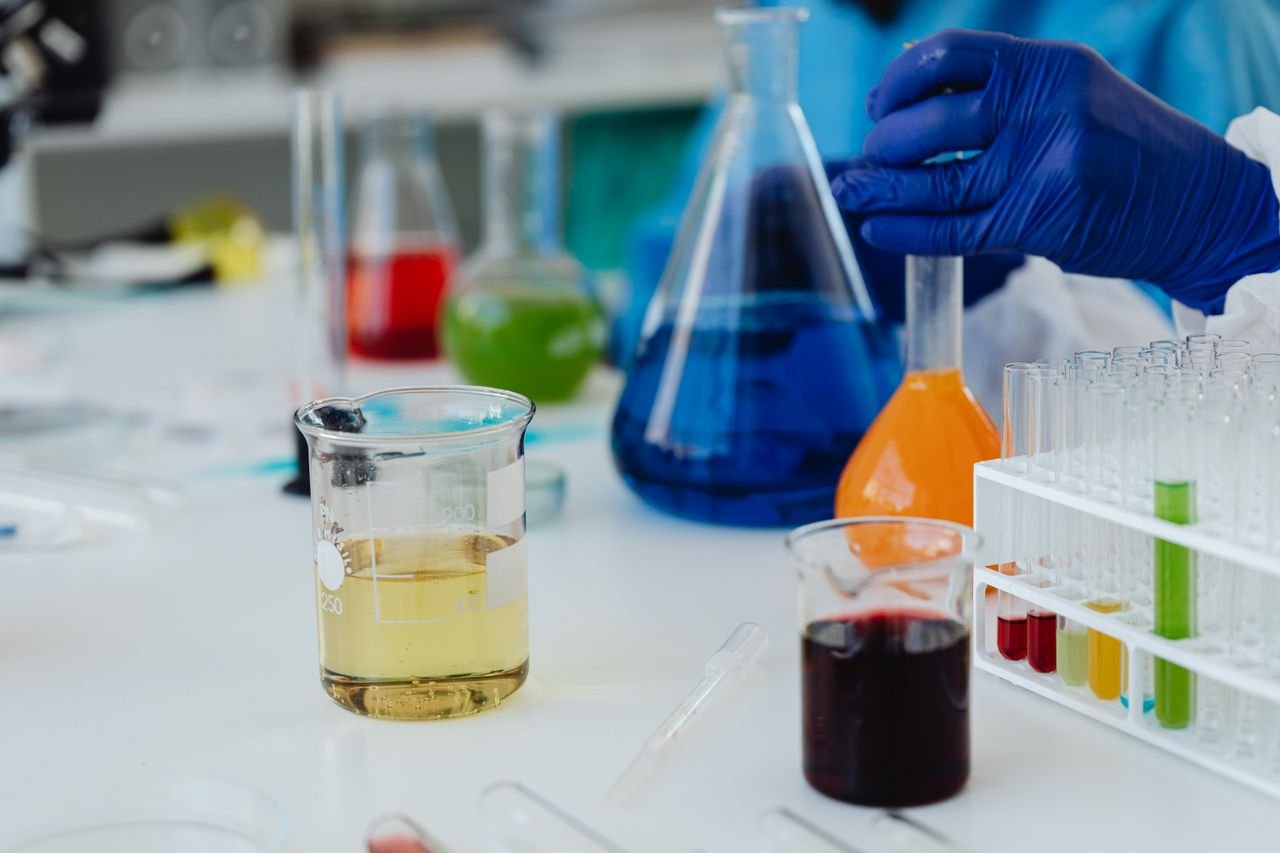 Colorful liquids in laboratory glassware and test tubes during a scientific experiment.